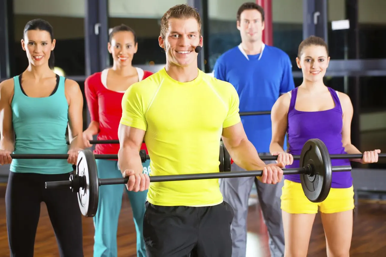 Strength training equipment including dumbbells, barbells, resistance bands, and smith machine in a modern gym.